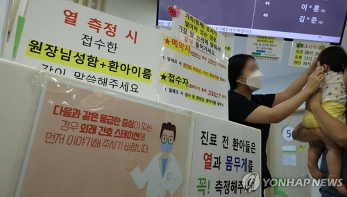 지난 13일 오전 성북구 성북우리아이들병원이 의료진이 체온을 재고 있다. 최근 전국적으로 코로나19 재확진자가 늘어나면서 일부 지역에서는 어린이 환자도 많이 늘어나고 있다. [연합뉴스]
